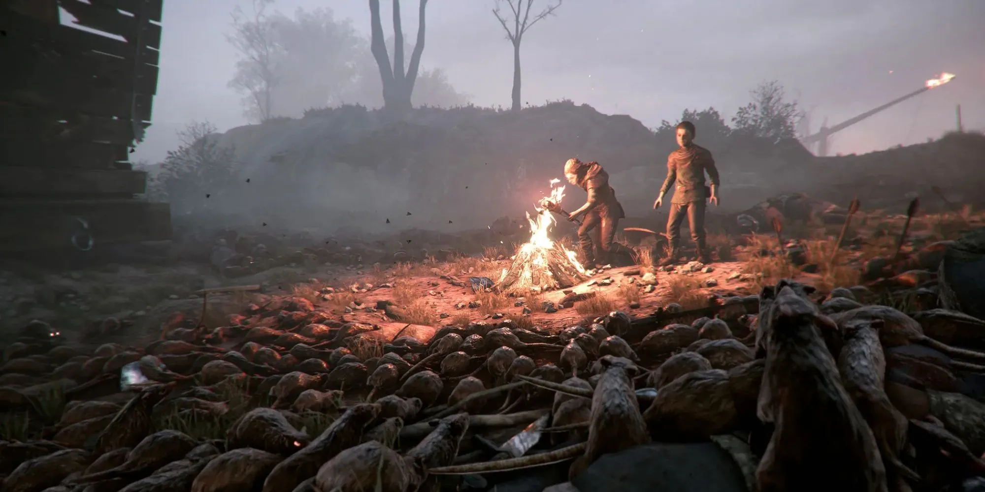 Amicia và Hugo trong A Plague's Tale bị bao vây bởi bầy chuột khát máu dưới ánh đuốc leo lét
