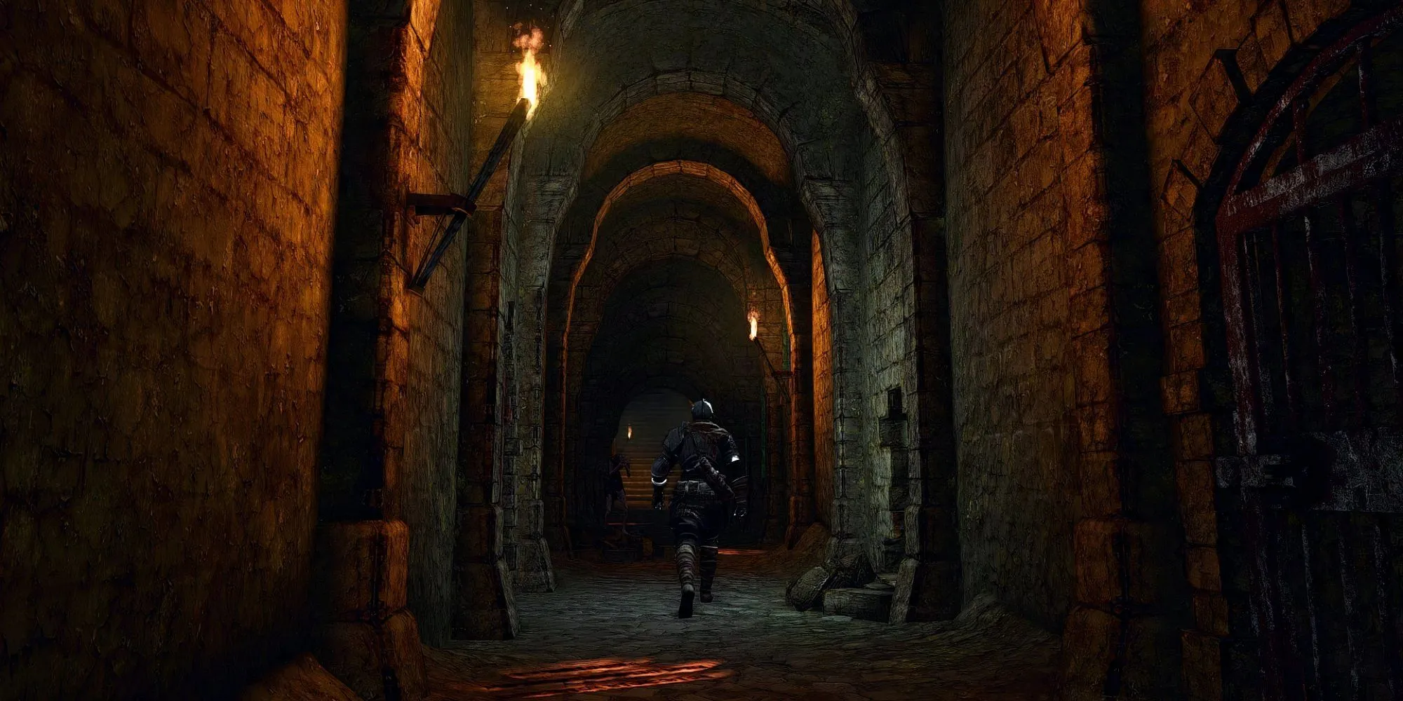 Nhân vật Undead chiến đấu với Asylum Demon trong khu vực Undead Asylum của Dark Souls 1, một nhà tù u ám và đổ nát.