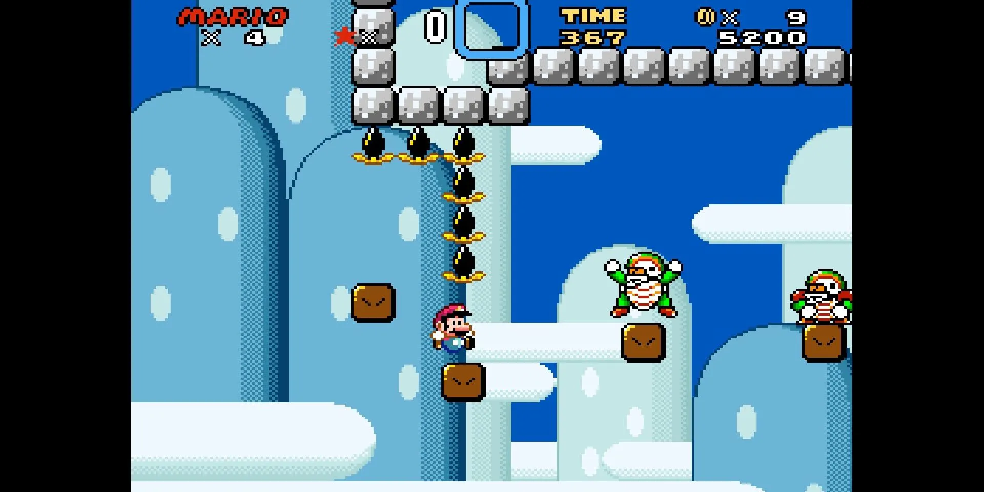 Mario nhảy trên các nền tảng chênh vênh và né Bullies trong ảnh chụp màn hình Kaizo Mario