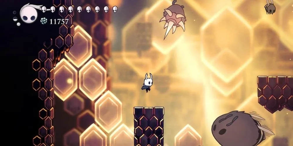 Nhân vật chính thực hiện pha platforming trên nền tổ ong trong Hollow Knight